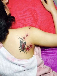 性格开朗的赵小姐背部肩膀处的迷人蝶恋花纹身图案