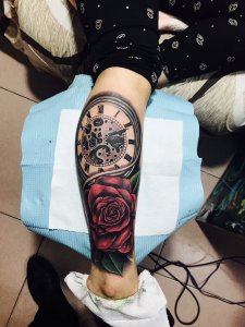 设计师金先生小腿处的时钟与玫瑰纹身图案
